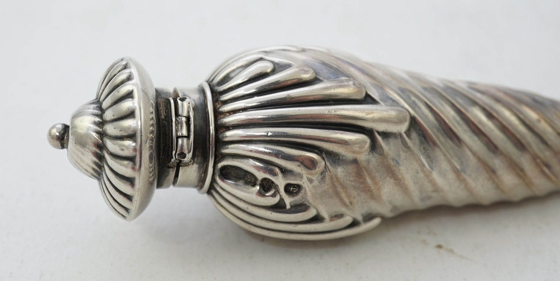 A late Victorian silver scent flask, of spiral tear drop form, with hinged cover and glass stopper